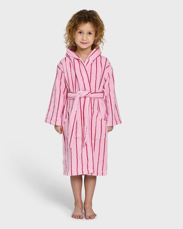 Mädchen im Kinderbademantel NARAM in Baby Pink & Ski Patrol Red, babyrosa mit roten Streifen, von vorn vor hellgrauem Hintergrund