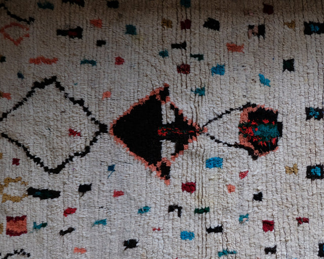 Detail: Raute aus dünnen Linien, dunkles Dreieck mit korallfarbenem Rand und bunte Quadrate