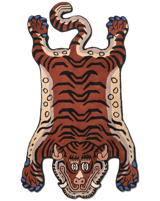 Wollteppich FRANKIE TIGER RUG von Bongusta in Tigerform, rostbraun mit schwarzen Streifen, cremeweißem Rand und blau lackierten Krallen, von oben auf Weiß