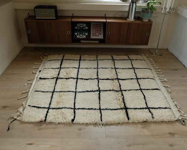 Berberteppich GEO B/W 1,56 x 2,08 m im Raum: cremeweißer Flor mit schwarzem Gitter und Fransen