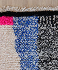 Teppichende mit Streifen in Neonpink, Blau und Schwarz-Weiß, dunkler Kante und hellen Fransen