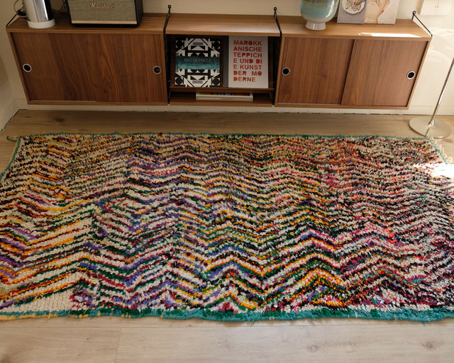Boujad STRIPE ME CRAZY 1,25 x 2,34 m im Raum: bunte Zickzackstreifen mit türkisfarbener Kante