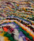 Nahaufnahme des bunten Flors mit grünen, gelben und lila Fäden