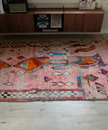 Vintage-Boujad 1,53 x 2,60 m im Raum: verwaschenes Rosé mit orangen Rauten und Schachbrettborte