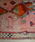 Detail: orange Rauten und kleine Motive in Weiß und Weinrot, unten die Schachbrettborte