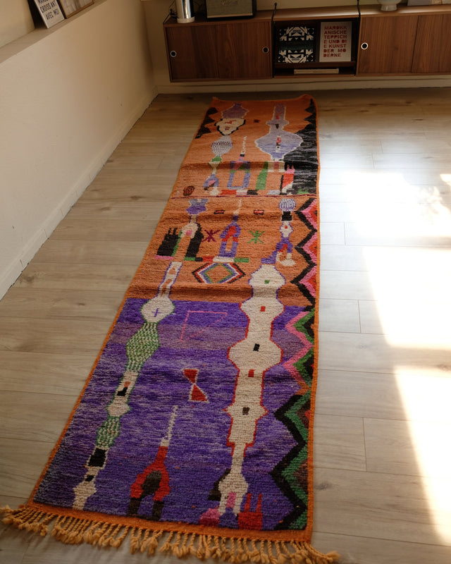 Vintage-Läufer PATTERN 0,82 x 3,36 m im Raum: eine Hälfte Orange, eine Hälfte Lila, mit bunten Figuren