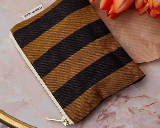 Geldbeutel MARIE Stripes Cumin auf Marmor neben orangefarbenen Tulpen