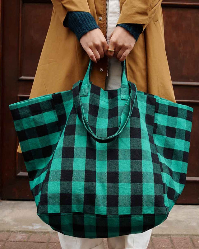 Tote Bag ELISA in Big Vichy Green, mit beiden Händen vor einem Mantel gehalten