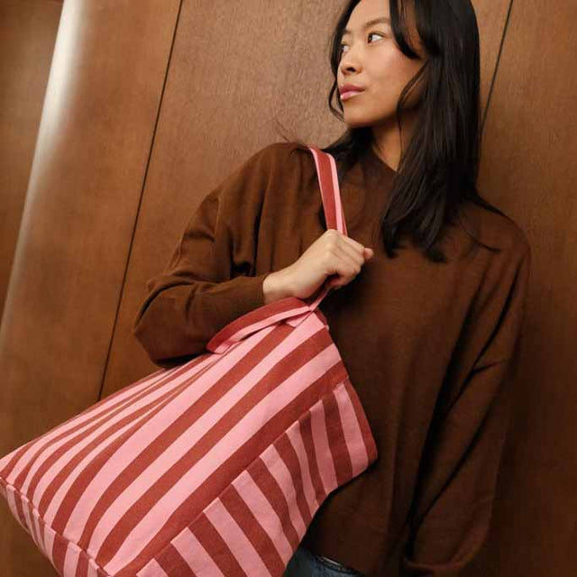 Frau im braunen Pullover mit der Tote Bag ELISA in Brick/Pink über der Schulter